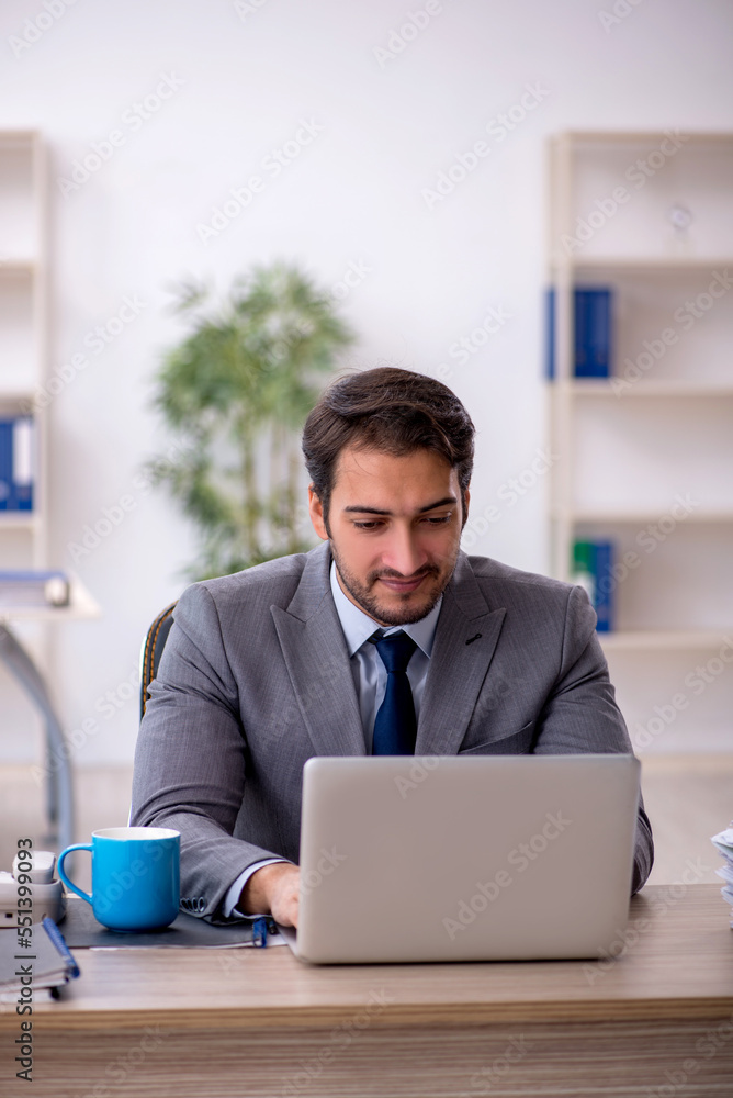 Young male employee and too much work in the office Young male employee and too much work in the office