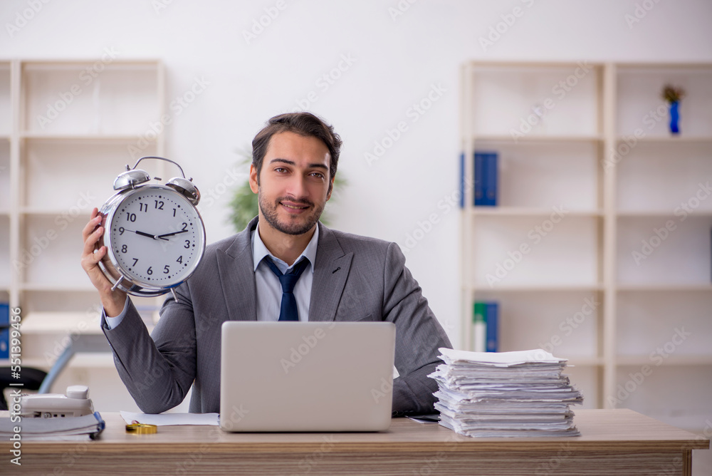 Young male employee in time management concept