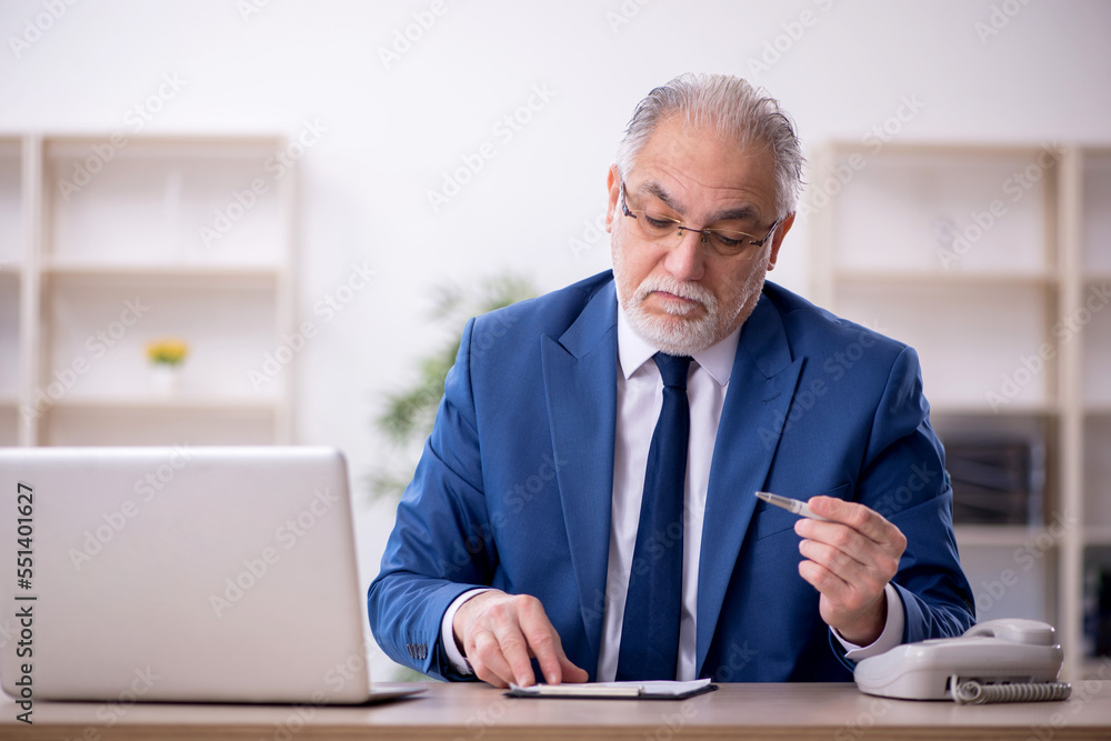 Old male boss working at workplace Old male boss working at workplace