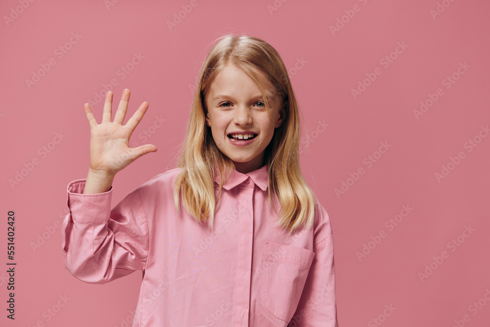 cute, beautiful, happy girl in pink clothes posing in the studio on a pink background showing five fingers and smiling broadly cute, beautiful, happy girl in pink clothes posing in the studio on a pink background showing five fingers and smiling broadly