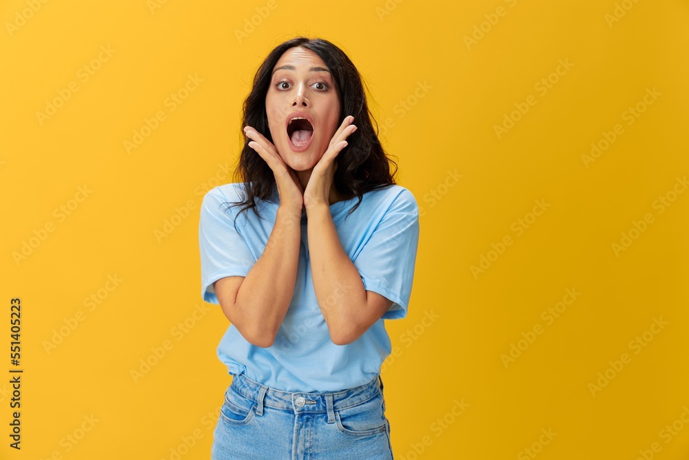 Woman signal smile with teeth emotion portrait in blue t-shirt on yellow background, hands up, surprise, lifestyle, copy space Woman signal smile with teeth emotion portrait in blue t-shirt on yellow background, hands up, surprise, lifestyle, copy space