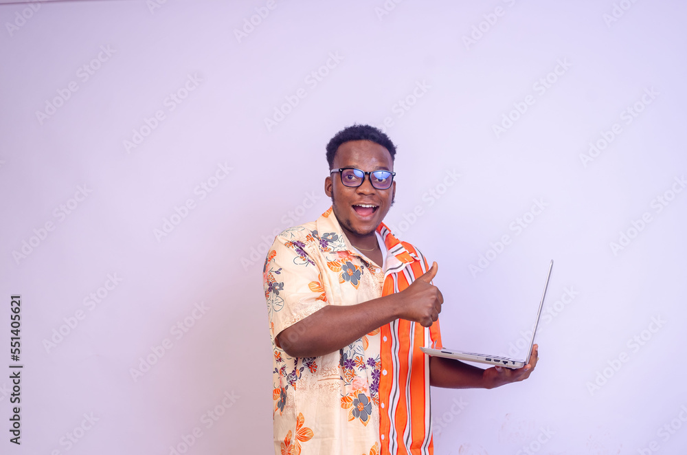 Young smiling african american man standing and using laptop computer isolated over white background. thumbs up Young smiling african american man standing and using laptop computer isolated over white background. thumbs up