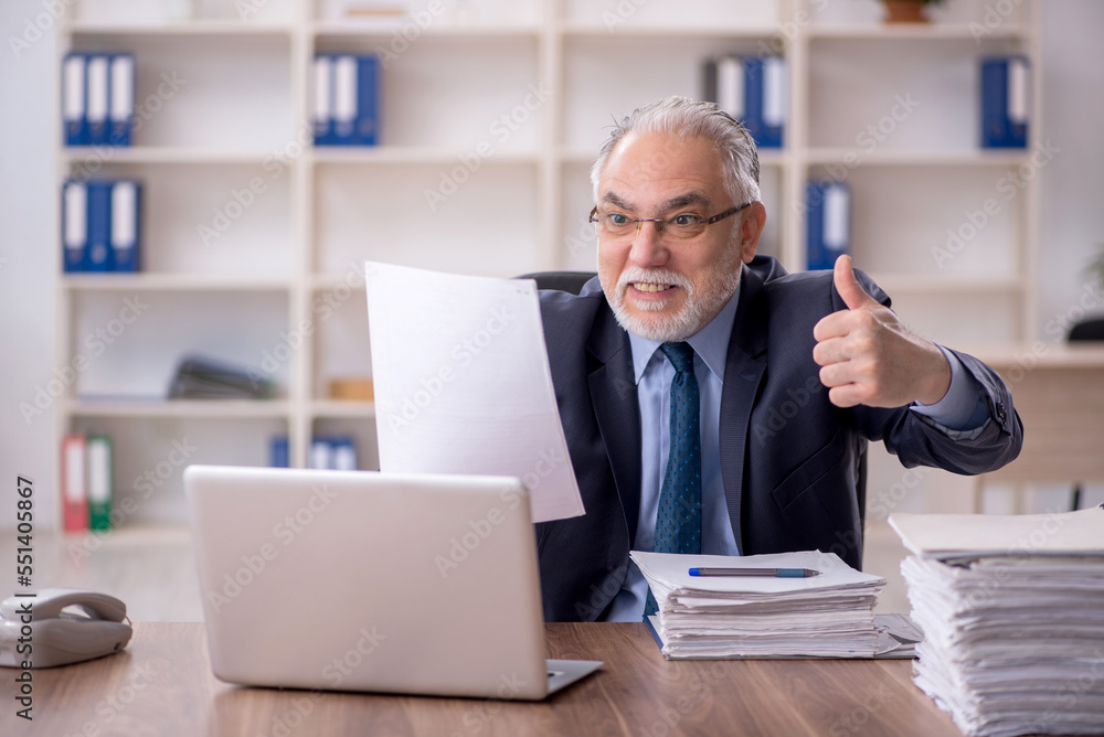 Old male employee working in the office Old male employee working in the office