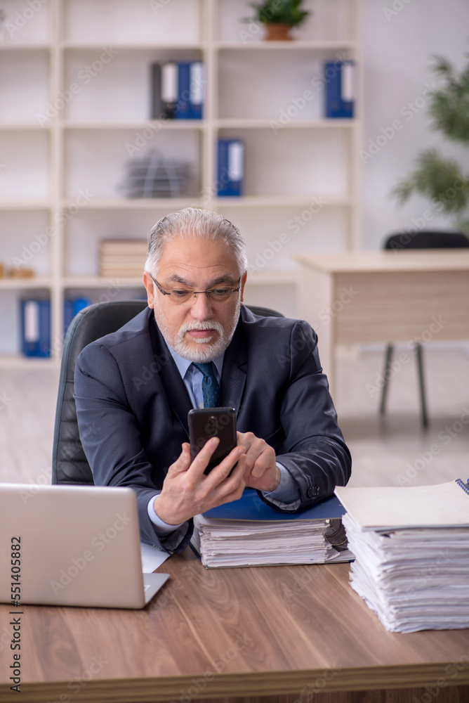 Old male employee working in the office Old male employee working in the office