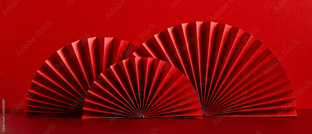 Happy Chinese New Year 2023 year of the rabbit concept. Oriental asian style paper fans on red table. Minimal style.