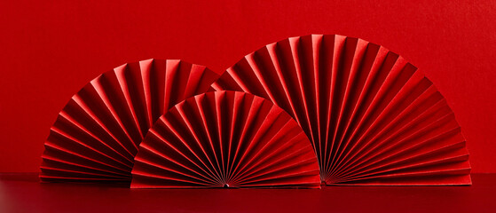 Happy Chinese New Year 2023 year of the rabbit concept. Oriental asian style paper fans on red table. Minimal style.