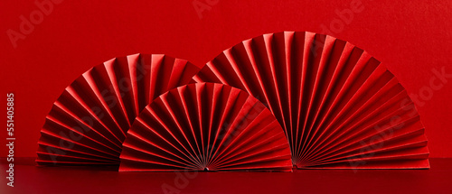 Happy Chinese New Year 2023 year of the rabbit concept. Oriental asian style paper fans on red table. Minimal style.