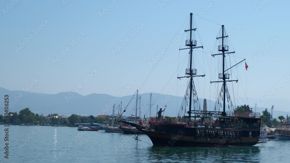 Tourists ride on pirate boat. A view of big tourism ship stay in calm sea water under sun in summer. Tourists ride on pirate boat. A view of big tourism ship stay in calm sea water under sun in summer.