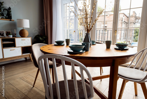 Wooden table with chairs in the living room. Stylish modern interior in Scandinavian style. © Raisa Kanareva