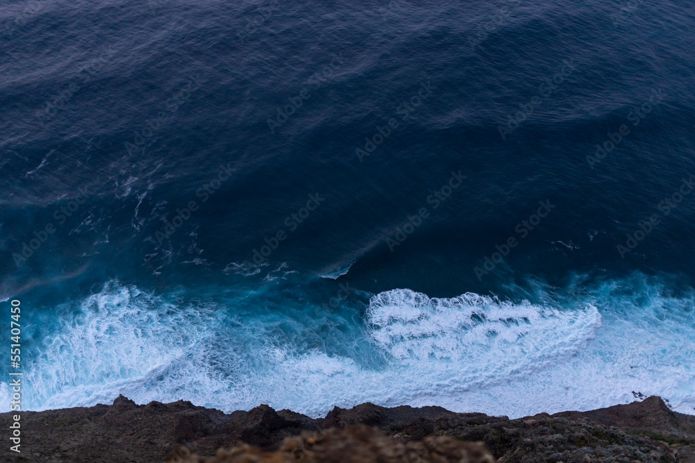 Obraz premium ocean surf waves at sunset view from above