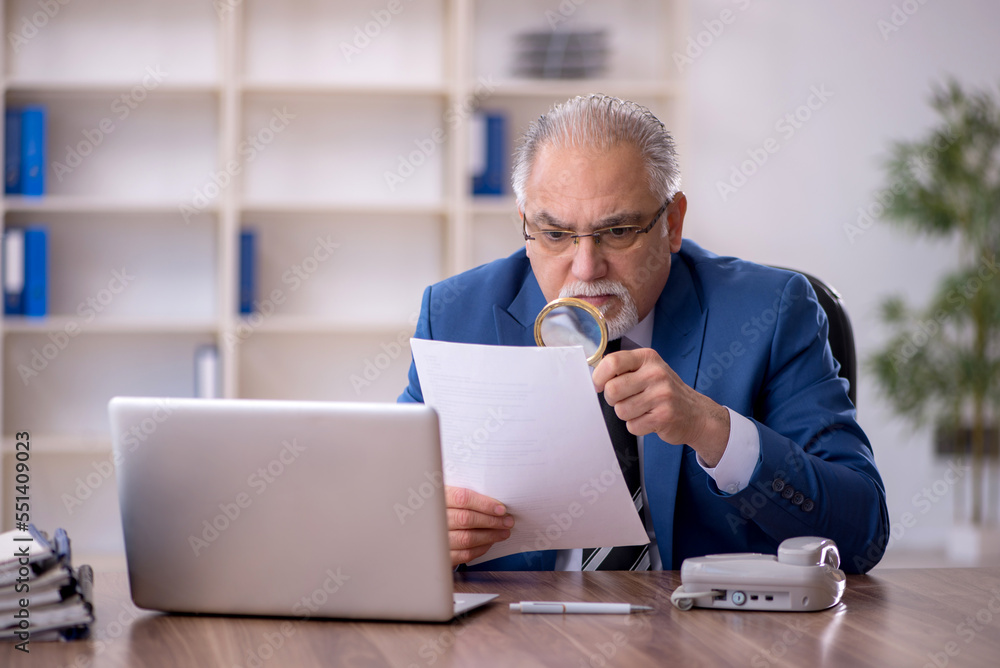 Old male employee working in the office Old male employee working in the office