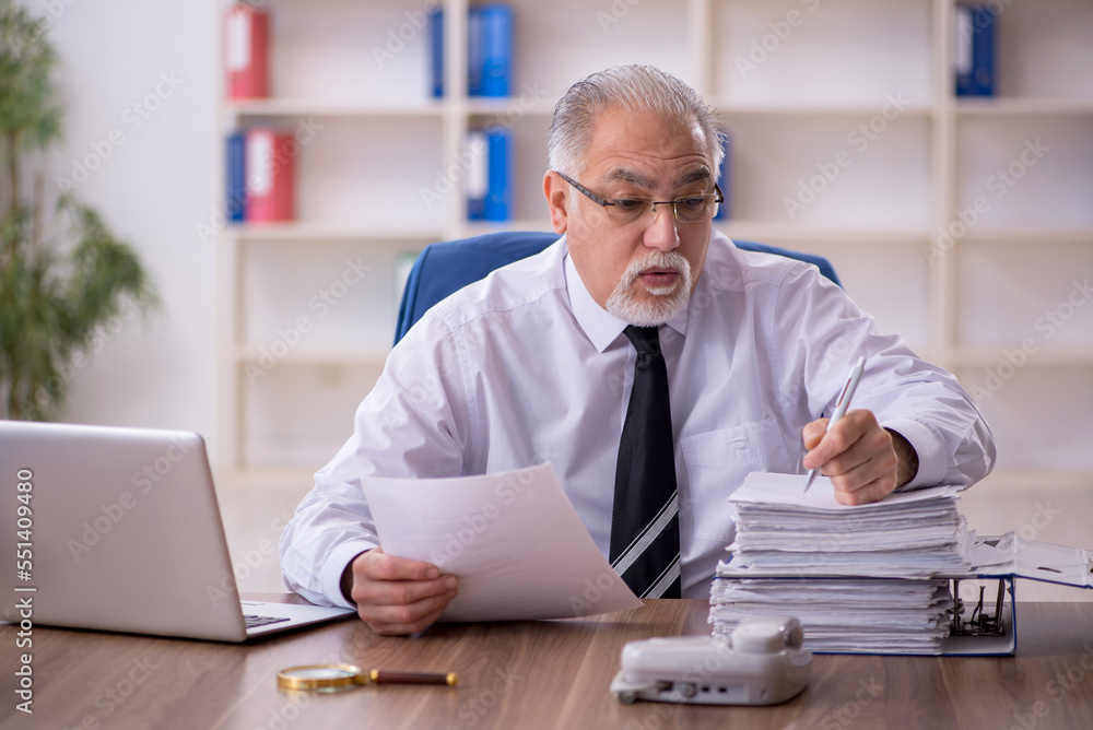 Old male employee working in the office Old male employee working in the office