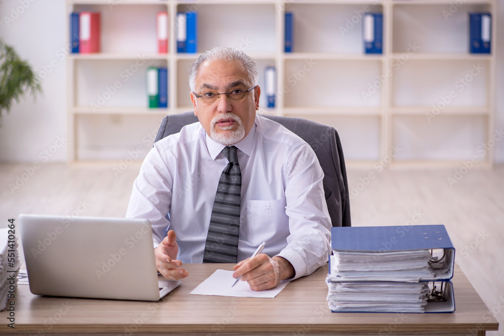 Old male employee working in the office Old male employee working in the office