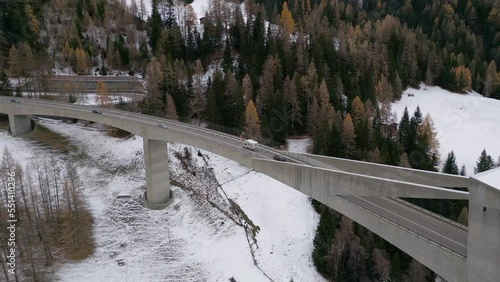 A camper drives over the big bridge in the Swiss mountains. The Ganter Bridge on the Simplon Pass connects Switzerland with Italy. Aerial Shot