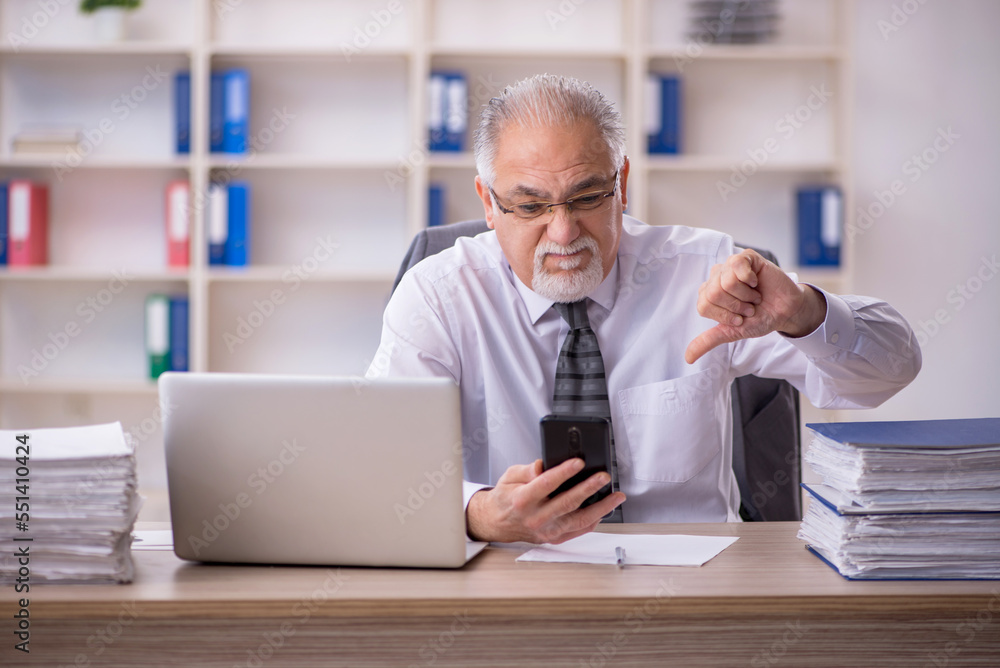 Old male employee working in the office Old male employee working in the office
