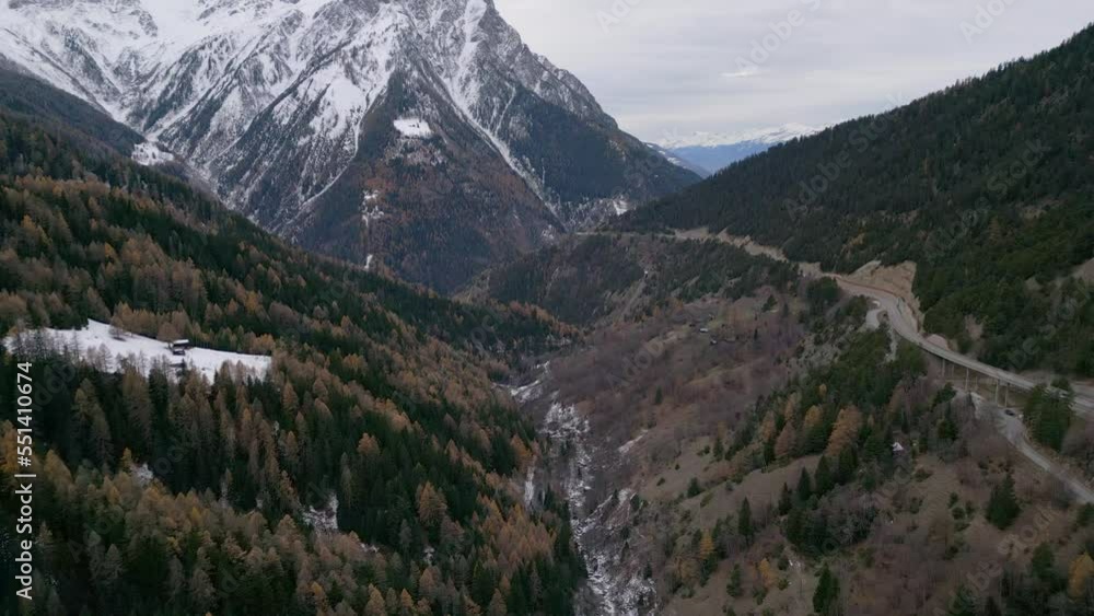 Wide view over the valley in the mountains. It is still autumn and the forest is colored and there is already the first snow. Aerial Shot Wide view over the valley in the mountains. It is still autumn and the forest is colored and there is already the first snow. Aerial Shot