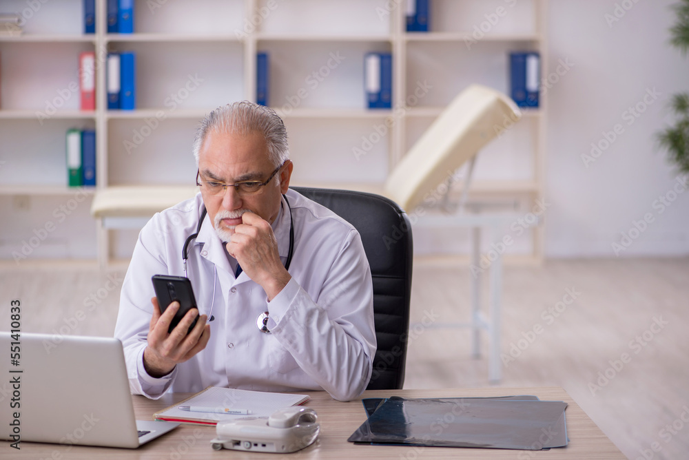 Fototapeta premium Old male doctor in telemedicine concept