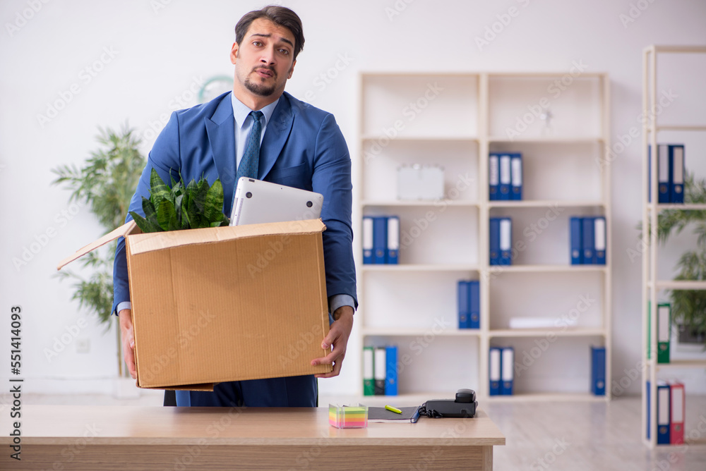Young male employee in business relocation concept Young male employee in business relocation concept