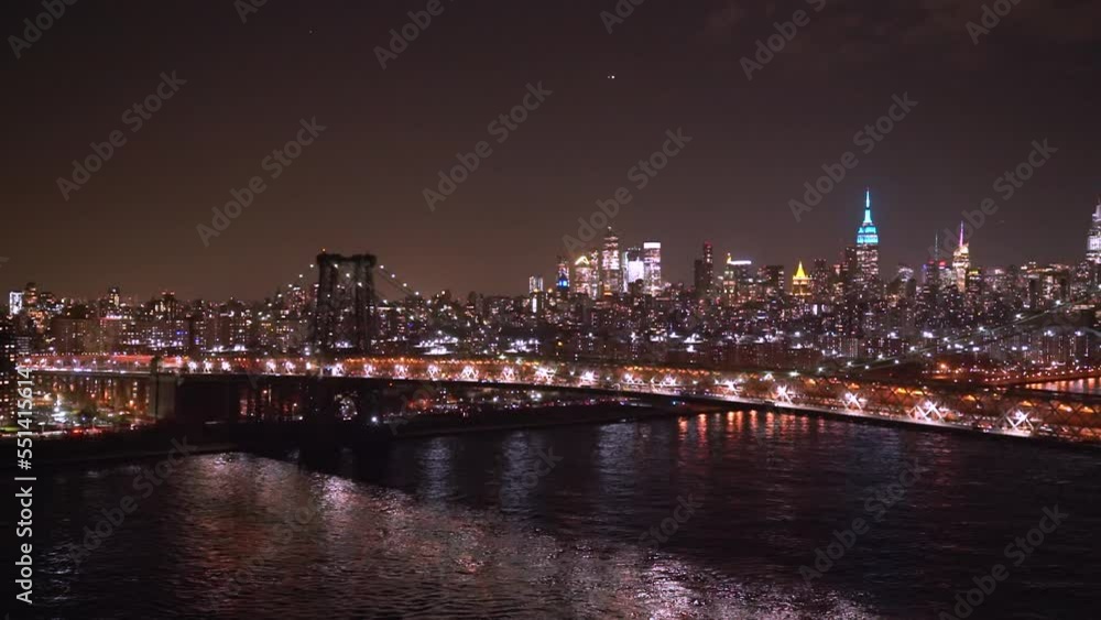 Williamsburg Bridge against the backdrop of East River and Manhattan at night Williamsburg Bridge against the backdrop of East River and Manhattan at night