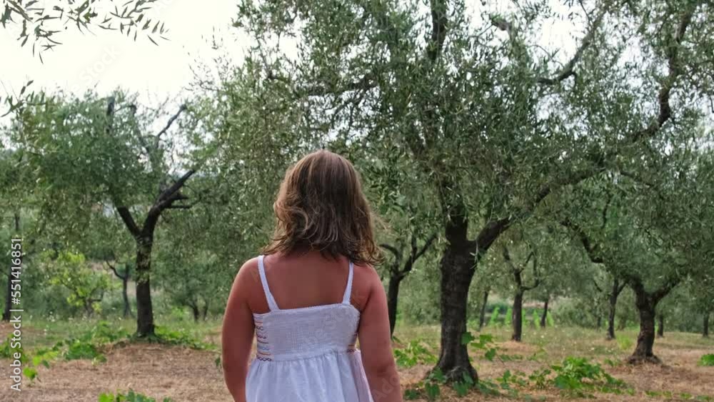 Beautiful Caucasian Girl in Simple Cotton Dress Walking Among Olive Trees in Tuscan Rural Area Beautiful Caucasian Girl in Simple Cotton Dress Walking Among Olive Trees in Tuscan Rural Area