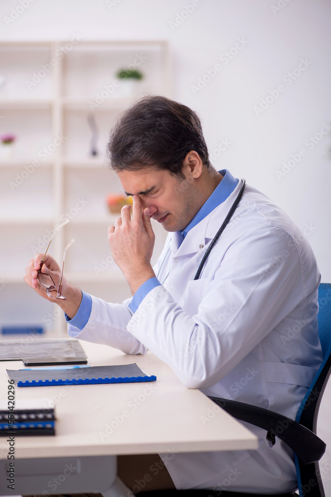 Young male doctor being tired after night shift Young male doctor being tired after night shift