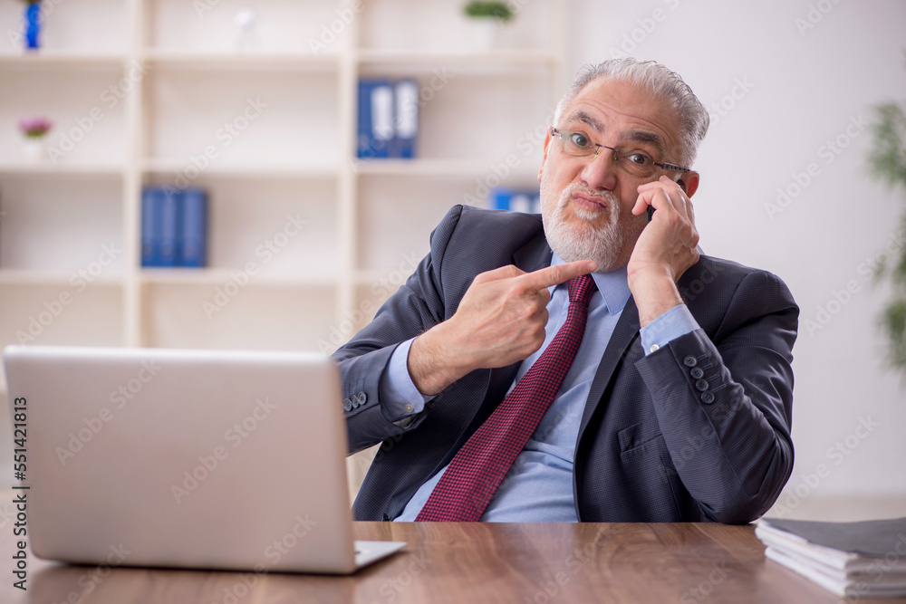 Old male boss employee working in the office Old male boss employee working in the office