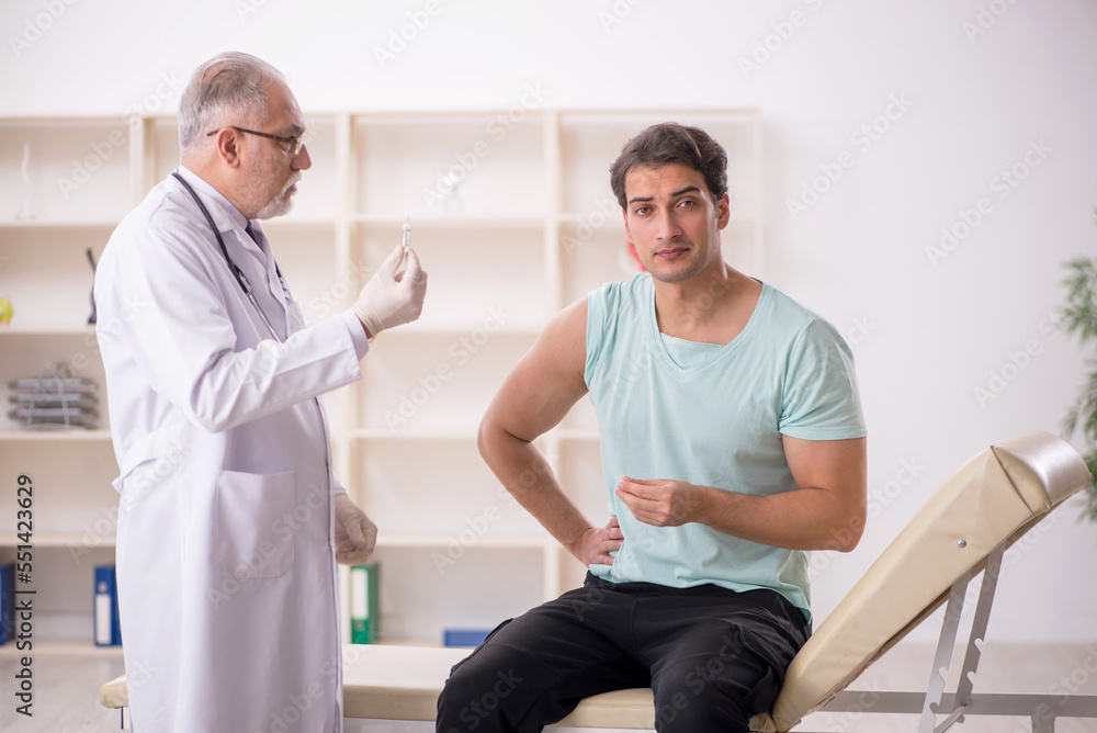 Young male patient visiting old male doctor in vaccination conce Young male patient visiting old male doctor in vaccination conce