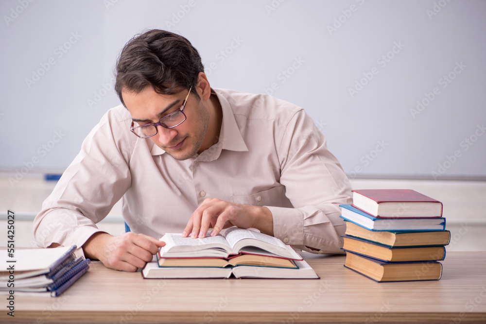 Young male teacher student sitting in the classroom Young male teacher student sitting in the classroom