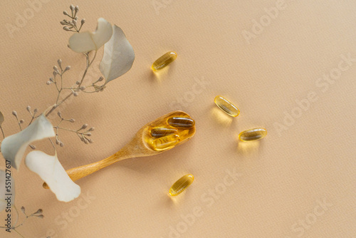 Vitamins on a white background. Capsules on spoon suitable for: fish oil, omega 3, omega 6, omega 9, vitamin A, vitamin D, vitamin D3, vitamin E. Health concept photo