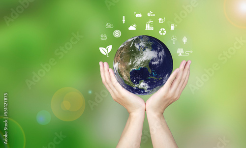 Renewable energy concept, male hand holding globe, energy saving model showing alternative energy icon, environmental protection and finance Investing in energy stocks around the world