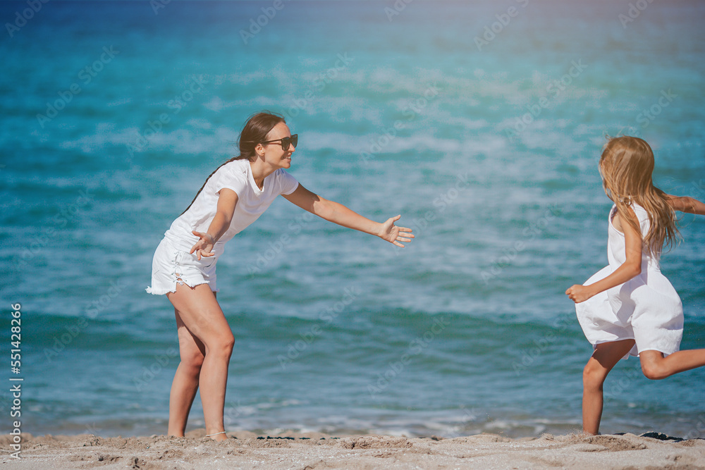 Young happy mother and and her daughter having fun on the beach Young happy mother and and her daughter having fun on the beach