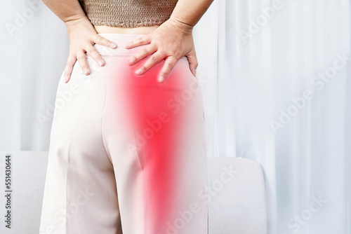 Sciatica Pain concept with woman suffering from buttock pain spreading to down leg photo