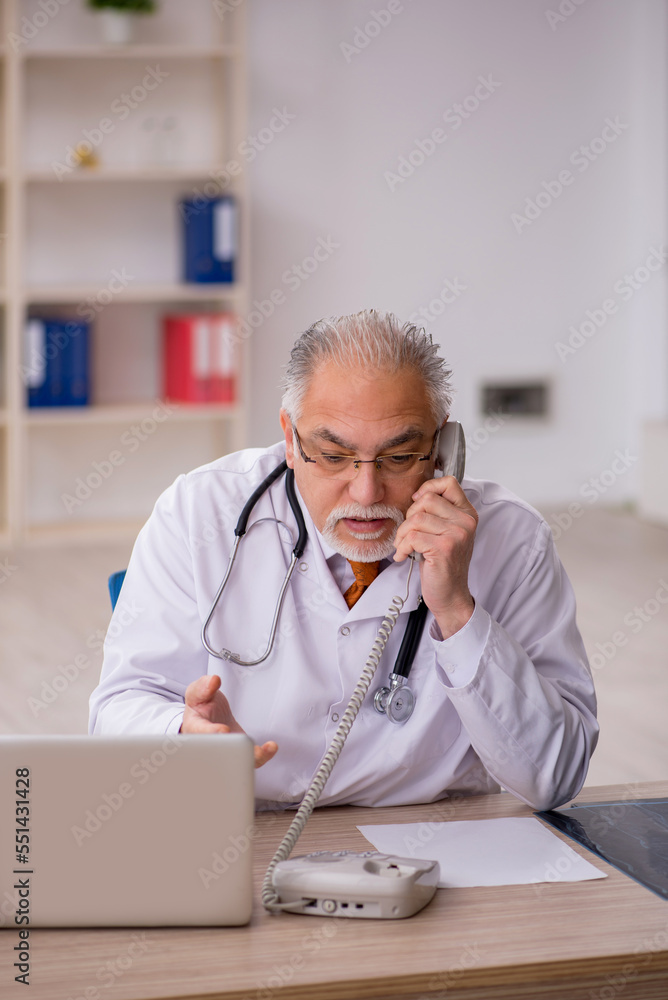Old male doctor in telemedicine concept Old male doctor in telemedicine concept