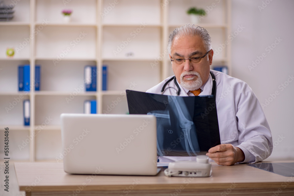 Old male doctor radiologist working in the clinic Old male doctor radiologist working in the clinic