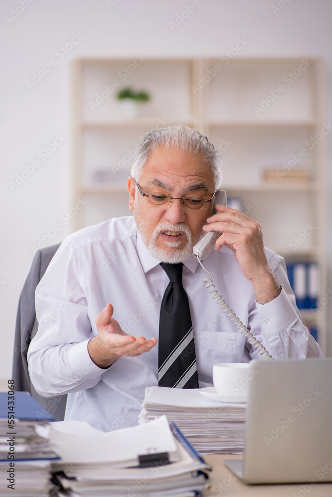 Old male employee working in the office Old male employee working in the office