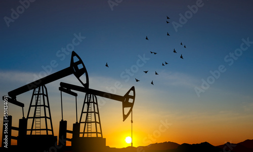 Silhouette of Oil pump. Industrial machine for petroleum on background of sunset