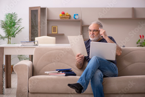 Old male employee working from home during pandemic