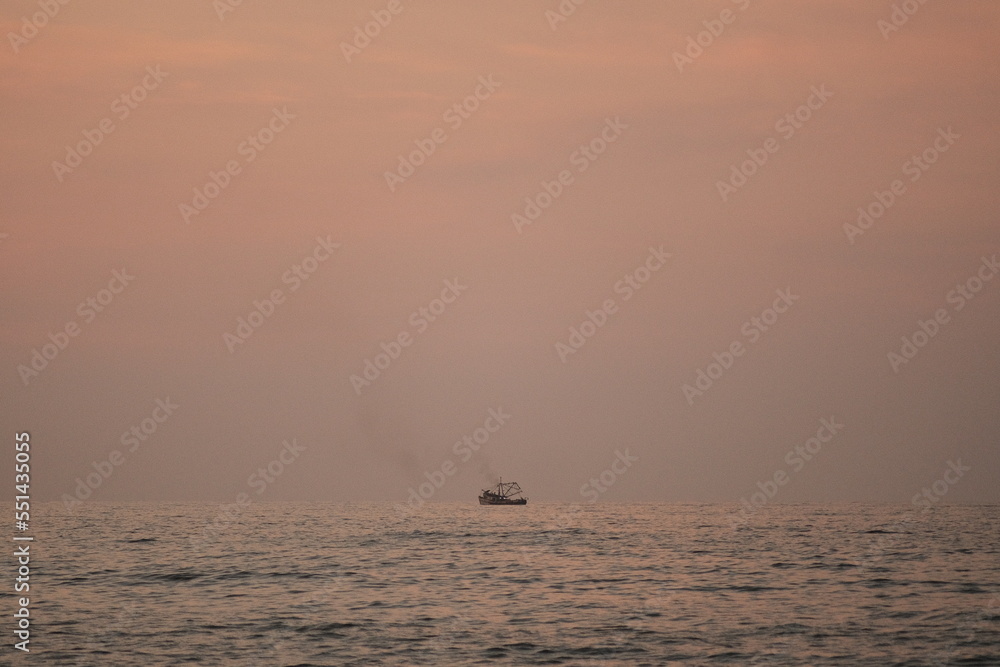 Boat in the horizon of a sunset in Sayulita, Nayarit, Mexico.