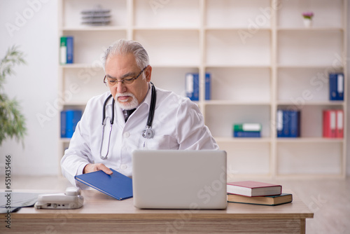 Old male doctor working in the clinic