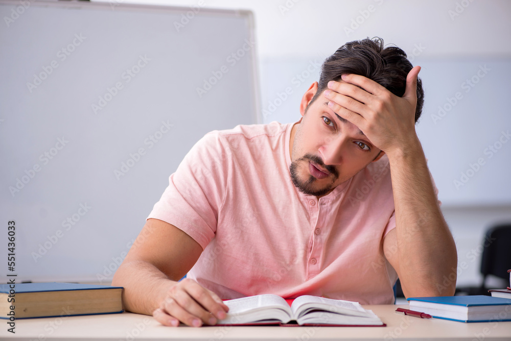 Young male student preparing for exams in the classroom Young male student preparing for exams in the classroom