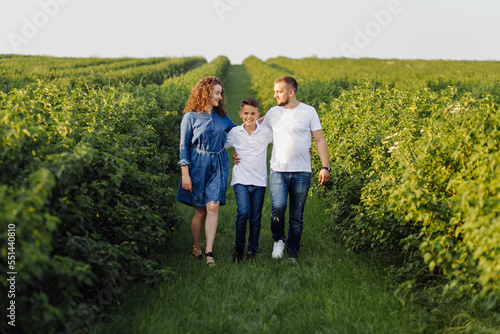Young family looking at the camera while walking in the garden