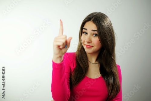 Close up portrait of gorgeous  nice  stunning  adorable good serious stylish girl raises finger up says Attention please Young stylish female teacher tries to explain something to pupils