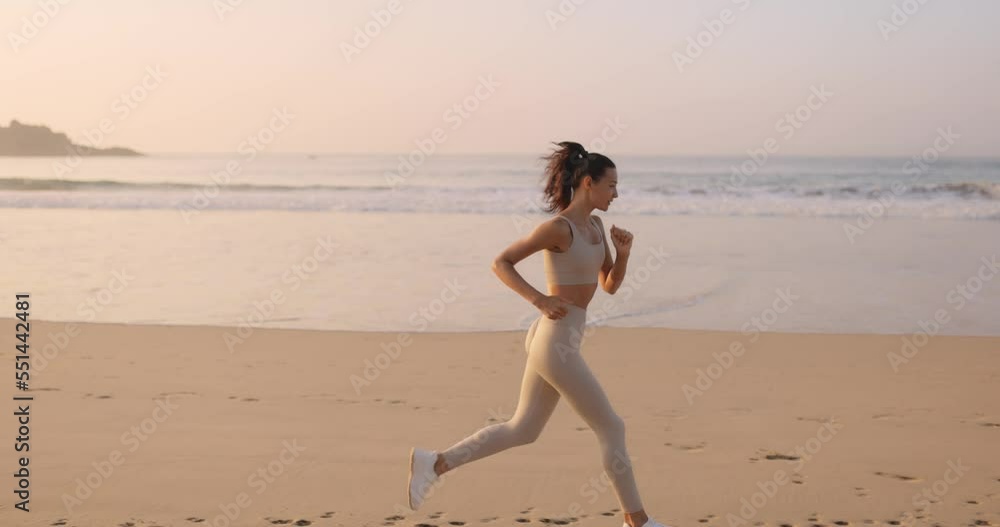 Female Runner Jogging During Outdoor Workout on the Beach in Slow Female Runner Jogging During Outdoor Workout on the Beach in Slow
