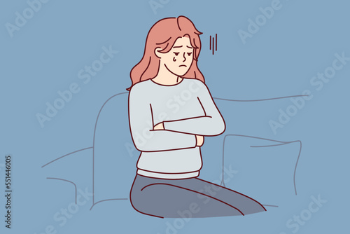 Upset woman crying sitting on couch because of breakup with boyfriend or death of loved one. Unhappy girl in casual clothes with arms crossed is going through after losing job. Flat vector image 