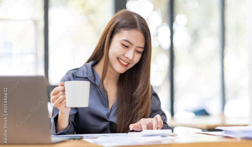 Asian Businesswoman Using laptop computer and working at office with calculator document on desk, doing planning analyzing the financial report, business plan investment, finance analysis concept.
Asian Businesswoman Using laptop computer and working at office with calculator document on desk, doing planning analyzing the financial report, business plan investment, finance analysis concept.