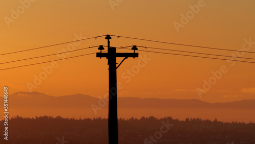Silhouette of an electric wire pole during a sunset over Metro Vancouver in British Columbia, Canada