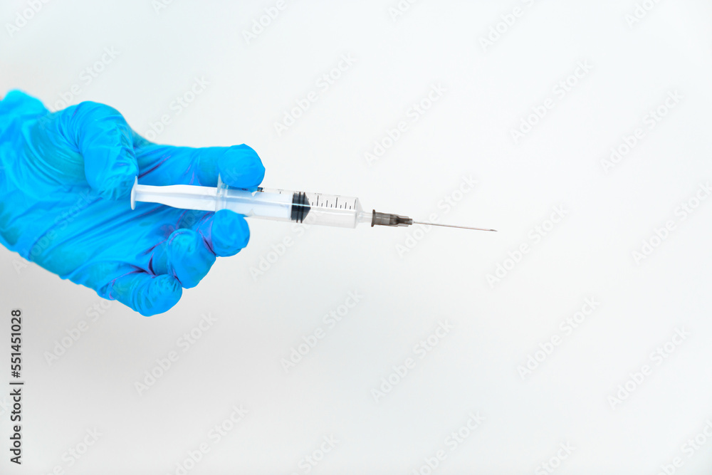 women's hands in blue gloves with a disposable syringe. women's hands in blue gloves with a disposable syringe.