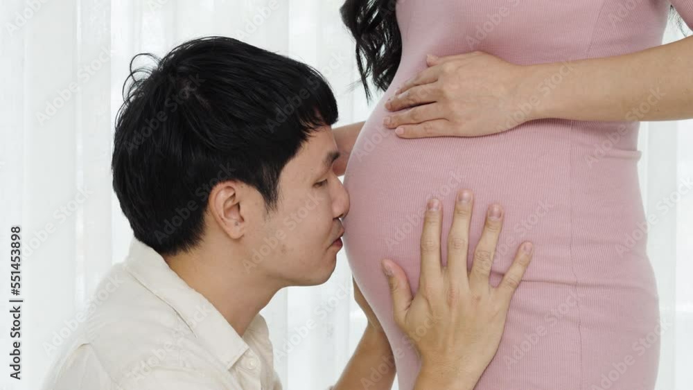 Husband kissing to his pregnant wife's belly Husband kissing to his pregnant wife's belly