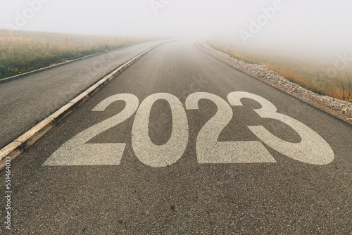 Fotografie 2023 new year uncertainty, number on asphalt road to infinity disappearing in fo