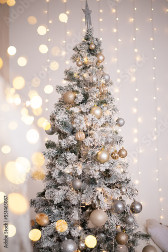 Christmas tree with gold and silver decorations. Christmas card with lights